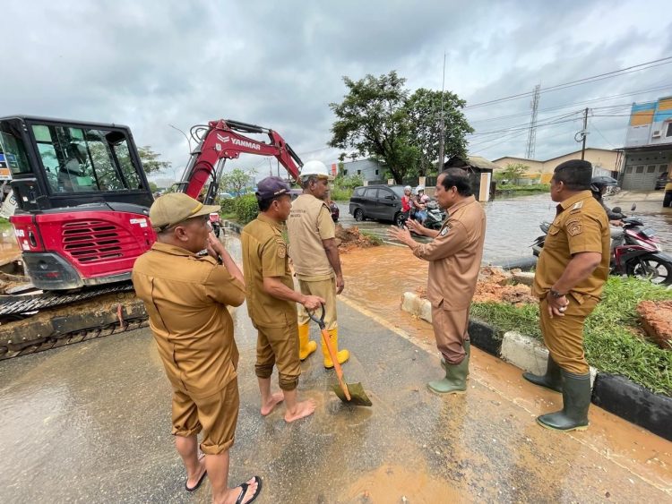 Kepala Dinas PUPR Kota Kendari, Ali Aksa saat memantau normalisasi genangan air di Jalan Bypass Kendari.